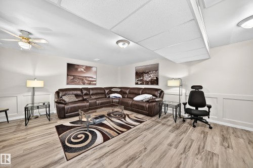 Spacious room featuring light wood-finish flooring, recessed lighting, and a ceiling fan - 11708 138 Avenue Nw, Edmonton, AB 