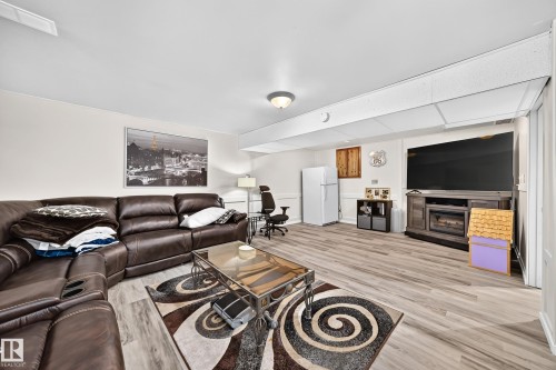 Spacious room featuring wood-finish flooring, a drop ceiling, and recessed lighting - 11708 138 Avenue Nw, Edmonton, AB 
