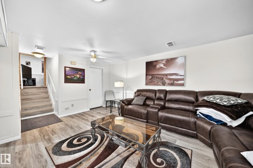 Spacious interior featuring wood-finish flooring, white paneled walls, a ceiling fan, and recessed lighting - 11708 138 Avenue Nw, Edmonton, AB 