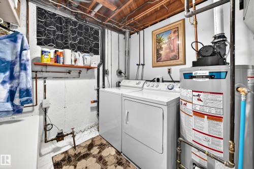 Dedicated laundry area featuring a white washing machine, white dryer, and a water heater - 11708 138 Avenue Nw, Edmonton, AB 