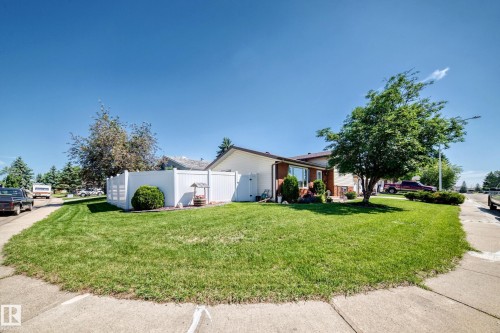 Expansive corner lot featuring a vinyl privacy fence, mature trees, and a well-maintained lawn - 11708 138 Avenue Nw, Edmonton, AB 