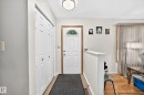 Entryway featuring a white paneled door with an arched window, light wood-finish trim, and a semi-flush mount ceiling light - 11708 138 Avenue Nw, Edmonton, AB 
