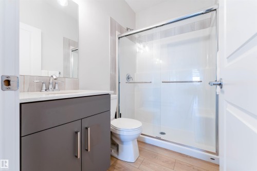 Modern bathroom featuring a single vanity with a gray cabinet, a white countertop, and a chrome faucet - 8426 228A Street Nw, Edmonton, AB - Indoor Photo Showing Bathroom