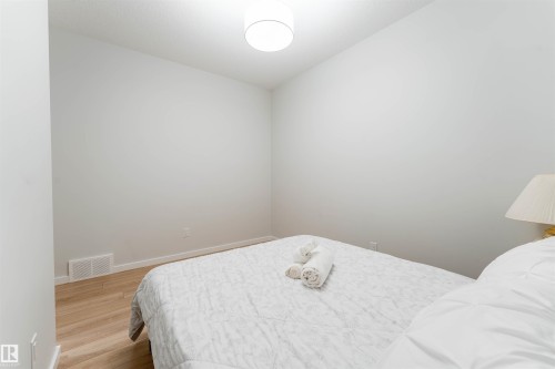 Room featuring light wood-finish flooring, white walls, and a contemporary ceiling light fixture - 8426 228A Street Nw, Edmonton, AB - Indoor Photo Showing Bedroom