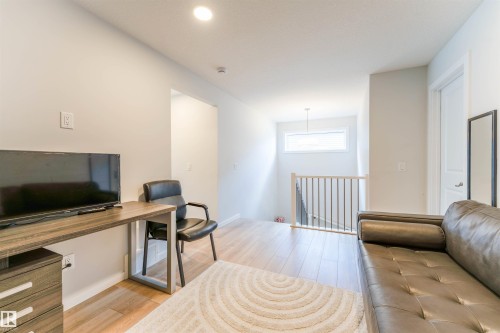 Versatile loft area featuring wood-finish flooring, recessed lighting, and a white spindle railing overlooking the staircase - 8426 228A Street Nw, Edmonton, AB - Indoor