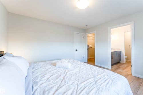 Light-toned walls complement wood-finish flooring throughout this room - 8426 228A Street Nw, Edmonton, AB - Indoor Photo Showing Bedroom