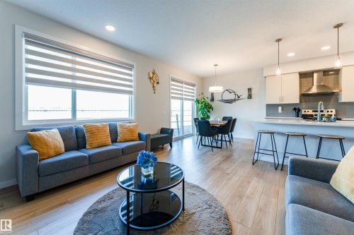 Open-concept living space featuring wood-finish flooring, recessed lighting, and large windows with horizontal blinds - 8426 228A Street Nw, Edmonton, AB - Indoor Photo Showing Living Room