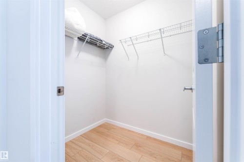 Well-appointed storage closet featuring wood-finish flooring and multiple wire shelving units - 8426 228A Street Nw, Edmonton, AB - Indoor With Storage