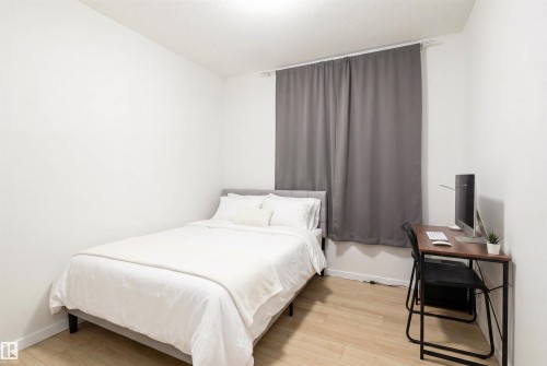 Light wood-finish flooring with white baseboards - 8426 228A Street Nw, Edmonton, AB - Indoor Photo Showing Bedroom