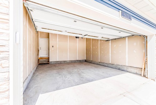 Spacious garage featuring a concrete floor, an overhead door, and an interior access door with steps - 8426 228A Street Nw, Edmonton, AB -  Photo Showing Other Room