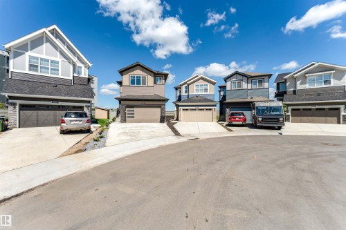 Contemporary homes featuring multi-tonal siding, prominent gables, large windows, attached garages with textured doors, and concrete driveways - 8426 228A Street Nw, Edmonton, AB - Outdoor With Facade