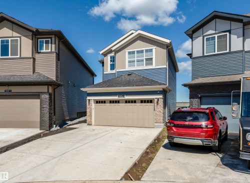 Contemporary two-story residence featuring a two-tone facade with blue siding and light grey accents - 8426 228A Street Nw, Edmonton, AB - Outdoor