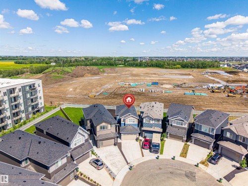 Cul-de-sac home featuring a two-story design with an attached garage, light-toned siding, and a dark roof - 8426 228A Street Nw, Edmonton, AB - Outdoor With View