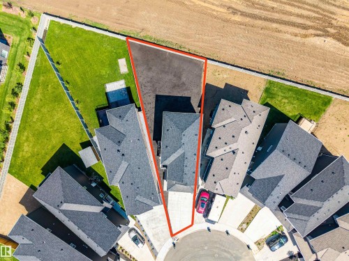 Aerial view showcasing a property with an irregular lot shape, bordered by a concrete perimeter and an undeveloped field - 8426 228A Street Nw, Edmonton, AB - Outdoor With View