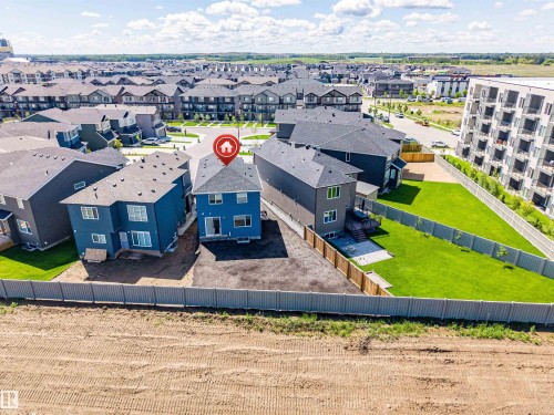 Rear aerial perspective showcasing a two-story residence with blue siding, dark roof, and multiple windows - 8426 228A Street Nw, Edmonton, AB - Outdoor With View