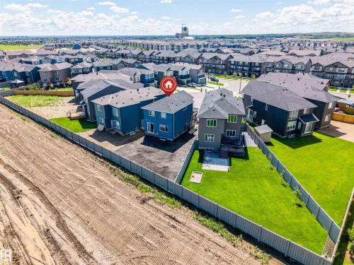 Two-story property with a dark grey roof and light grey siding, situated on a lot with a fenced backyard featuring a manicured lawn and a small patio area - 8426 228A Street Nw, Edmonton, AB - Outdoor With View