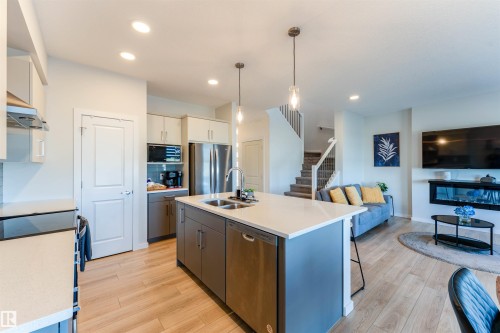Open-concept interior featuring wood-finish flooring - 8426 228A Street Nw, Edmonton, AB - Indoor Photo Showing Kitchen With Double Sink