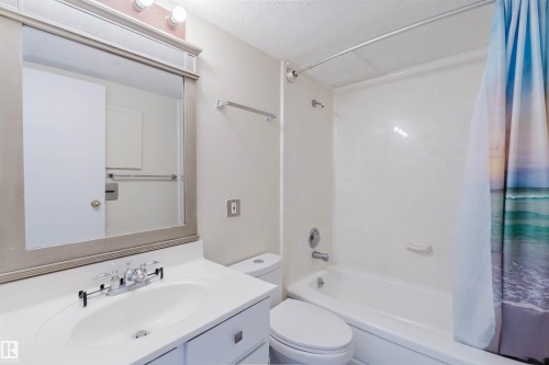 Bathroom featuring a vanity with an integrated sink, polished chrome faucet, and a large framed mirror - 904 10883 Saskatchewan Drive, Edmonton, AB 