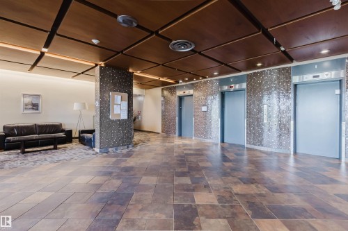 Lobby featuring multiple elevators, recessed lighting, and a wood-finish ceiling with integrated paneling - 904 10883 Saskatchewan Drive, Edmonton, AB 