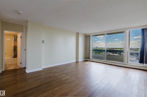 Expansive living area featuring wood-finish flooring and large windows - 904 10883 Saskatchewan Drive, Edmonton, AB 