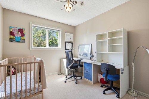 Neutral wall paint and carpeted flooring define this room, featuring a white-framed window - 11715 11B Avenue, Edmonton, AB 