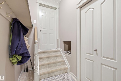 Entryway featuring light-toned wall paint and an overhead shelf with integrated coat hooks - 11715 11B Avenue, Edmonton, AB 