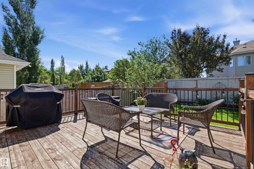 Expansive wood deck with dark railing and a fenced yard - 11715 11B Avenue, Edmonton, AB 