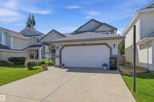 Contemporary residence featuring a two-car garage with a panel door, a concrete driveway, and gray-trimmed gables - 11715 11B Avenue, Edmonton, AB 
