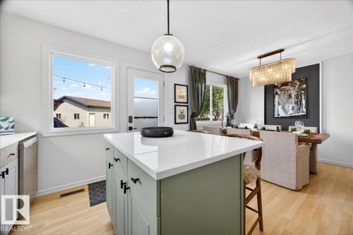 Kitchen island with a white countertop and green cabinetry - 3934 160 Avenue, Edmonton, AB 