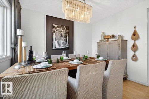 Dining area featuring a wood-finish floor and a rectangular chandelier - 3934 160 Avenue, Edmonton, AB 