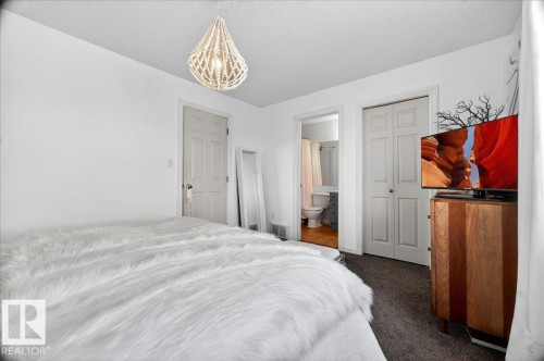 White walls with dark flooring and a hanging beaded light fixture - 3934 160 Avenue, Edmonton, AB 