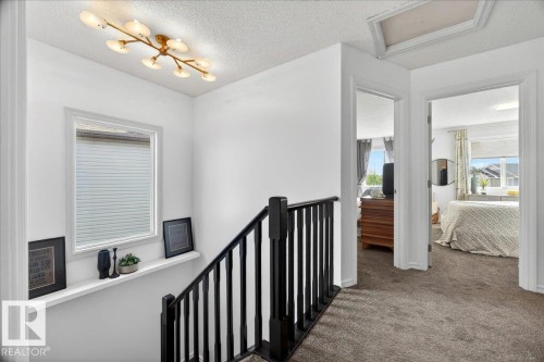 Upper-level hallway with dark carpeting and bright white walls - 3934 160 Avenue, Edmonton, AB 