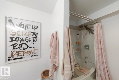 White-tiled bathtub with a built-in shower and shelving - 3934 160 Avenue, Edmonton, AB 