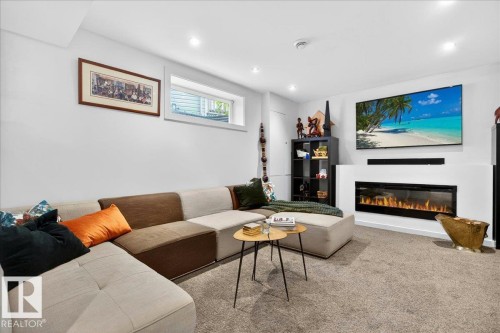 Spacious living area featuring light gray carpeting, an integrated electric fireplace, and recessed ceiling lighting - 3934 160 Avenue, Edmonton, AB 