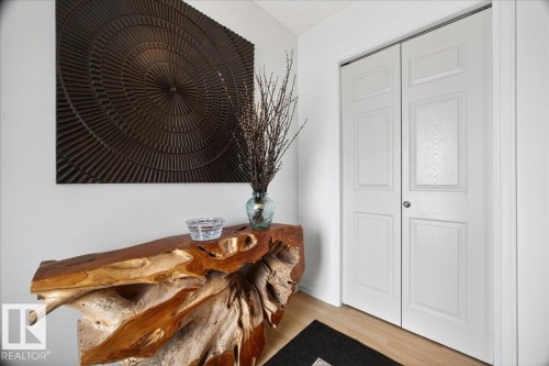 Light wood-finish flooring complements the white walls and matching bi-fold doors - 3934 160 Avenue, Edmonton, AB 