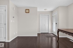 Entryway featuring rich wood-finish flooring, light neutral wall tones, white trim, and a white paneled front door with an integrated glass panel - 