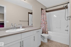 Bathroom featuring a vanity with an integrated sink, white cabinetry, and a shower-over-tub combination - 