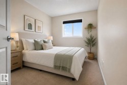 Neutral-toned bedroom featuring wall-to-wall carpeting and a white-framed window - 