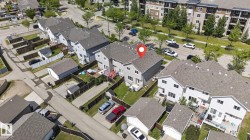 Aerial view of the property featuring a gray shingled roof, a fenced backyard with a wood deck, and a grass lawn - 