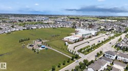 Expansive green space featuring a playground, sports fields, and paved walking paths - 