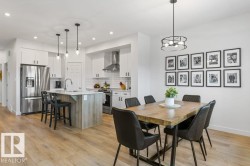 Open-concept kitchen and dining area featuring light wood-finish flooring - 