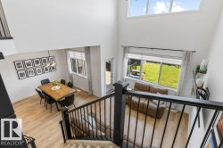 Open-concept living space featuring high ceilings and wood-finish flooring throughout - 
