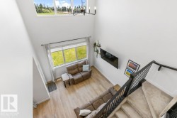Two-story living area with high ceilings and upper-level transom windows - 