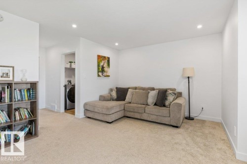 Carpeted living area featuring recessed lighting and a built-in shelving unit - 25 Nettle Crescent, St. Albert, AB 