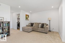 Carpeted living area featuring recessed lighting and a built-in shelving unit - 