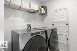 Dedicated laundry area featuring a washer and dryer, elevated wire shelving, and light-toned walls - 