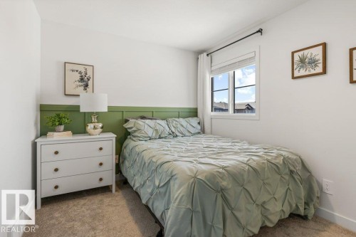 Carpeted room featuring a green accent wall with paneling, white window trim, and a double-pane window - 25 Nettle Crescent, St. Albert, AB 