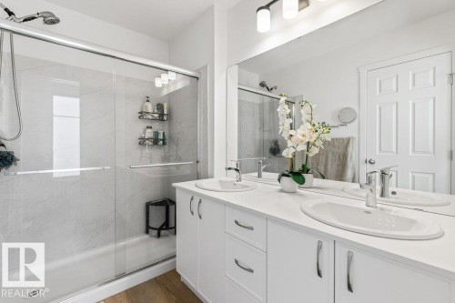 Contemporary bathroom featuring a double vanity with integrated sinks and chrome fixtures - 25 Nettle Crescent, St. Albert, AB 