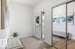 Entryway featuring a glass-paneled door, light wood-finish flooring, and a mirrored sliding closet door - 