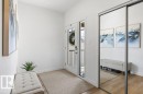 Entryway featuring a glass-paneled door, light wood-finish flooring, and a mirrored sliding closet door - 25 Nettle Crescent, St. Albert, AB 